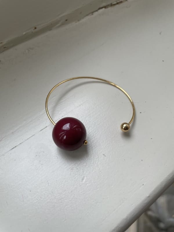 Pulsera rígida dorada con bola grande